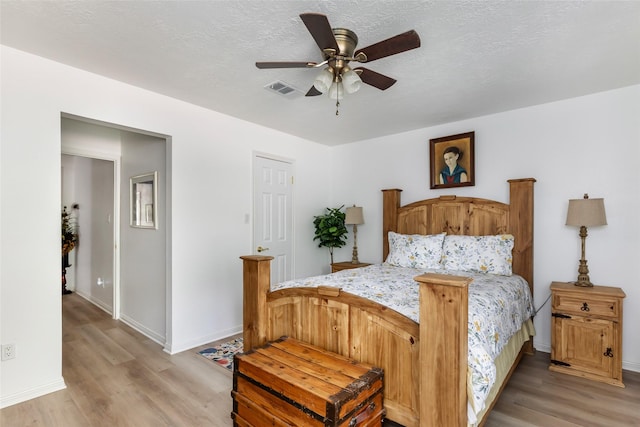 12121 Maverick Dr, Willis, TX 77378 - bedroom with light wood-type flooring, baseboards, a ceiling fan, and a textured ceiling