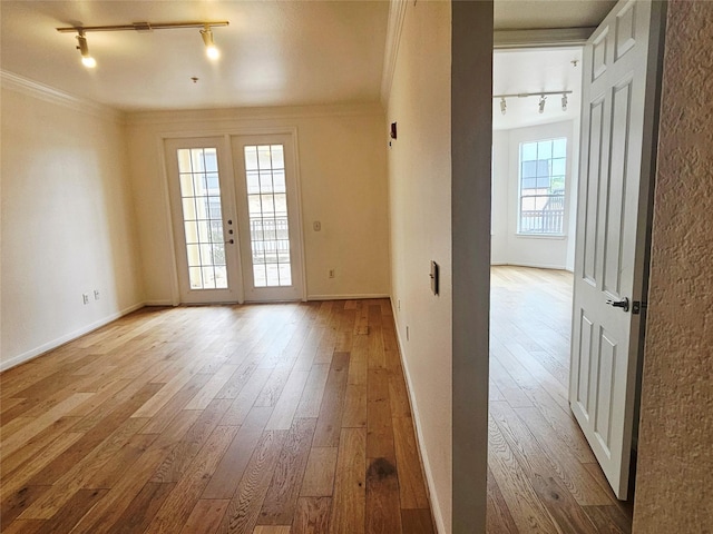 7575 Kirby Dr Unit 1104, Houston, TX 77030 - unfurnished room featuring track lighting, light wood-style flooring, baseboards, and crown molding