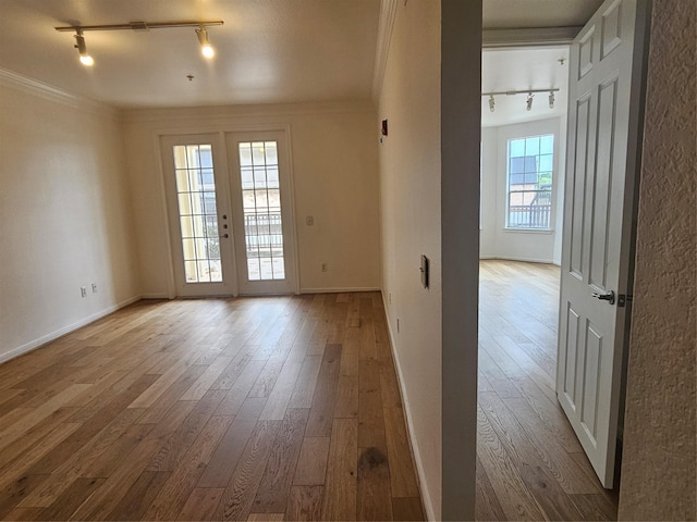 7575 Kirby Dr Unit 1104, Houston, TX 77030 - spare room with rail lighting, hardwood / wood-style floors, baseboards, and crown molding
