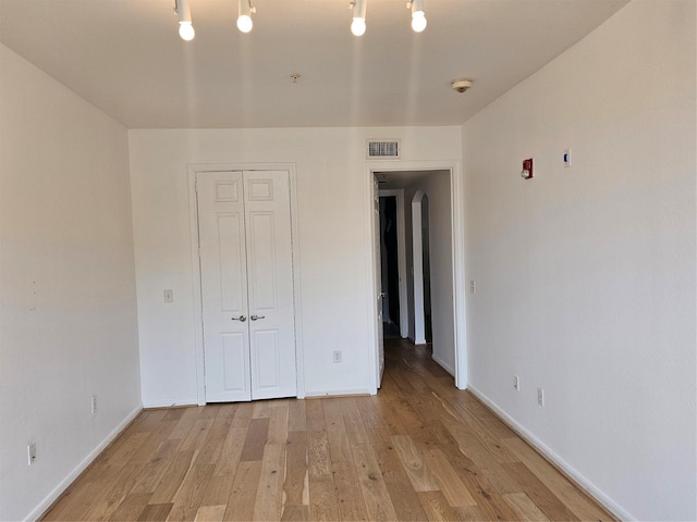 7575 Kirby Dr Unit 1104, Houston, TX 77030 - unfurnished bedroom with light wood finished floors, a closet, and baseboards