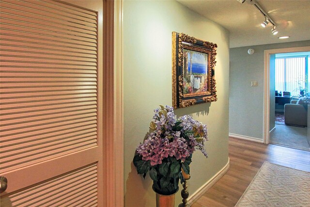 14655 Champion Forest Dr Unit 1102, Houston, TX 77069 - hall featuring track lighting, wood finished floors, and baseboards