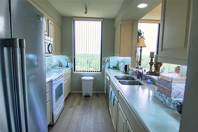 14655 Champion Forest Dr Unit 1102, Houston, TX 77069 - kitchen with appliances with stainless steel finishes, light countertops, light wood-type flooring, a sink, and healthy amount of natural light