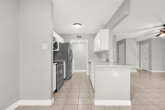 8385 Sands Point Dr Unit 5, Houston, TX 77036 - kitchen with appliances with stainless steel finishes, a sink, light tile patterned floors, ceiling fan, and white cabinetry