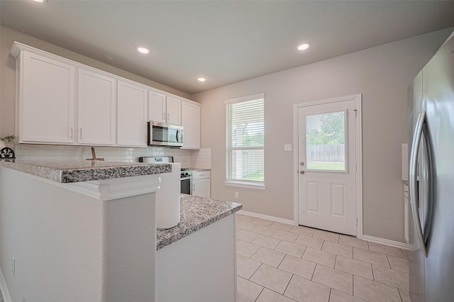 31630 Heguy Pass, Fulshear, TX 77441 - kitchen featuring stainless steel appliances, white cabinets, baseboards, tasteful backsplash, and recessed lighting