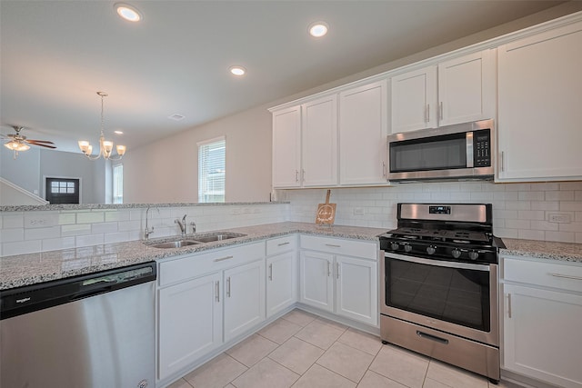 31630 Heguy Pass, Fulshear, TX 77441 - kitchen with appliances with stainless steel finishes, a sink, backsplash, light tile patterned floors, and recessed lighting