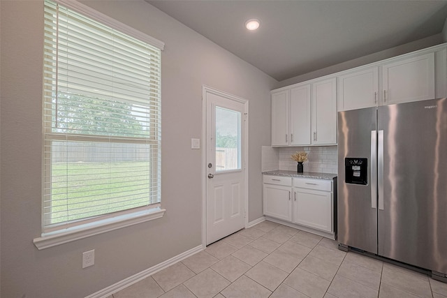 31630 Heguy Pass, Fulshear, TX 77441 - kitchen featuring stainless steel refrigerator with ice dispenser, light tile patterned floors, white cabinetry, tasteful backsplash, and light stone counters