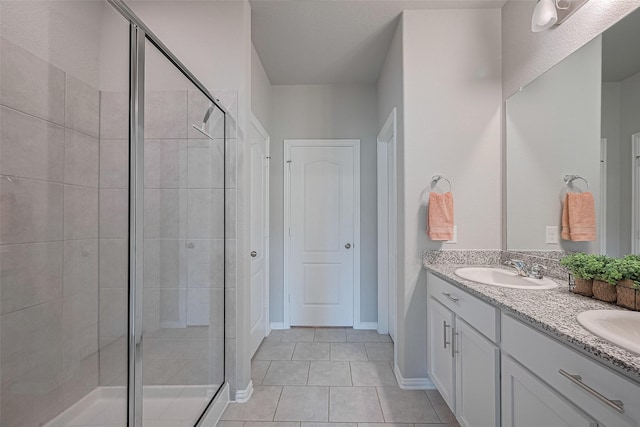 31630 Heguy Pass, Fulshear, TX 77441 - bathroom featuring a shower stall, double vanity, tile patterned flooring, and baseboards