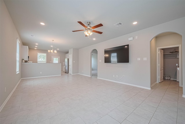 31630 Heguy Pass, Fulshear, TX 77441 - unfurnished living room with arched walkways, ceiling fan, recessed lighting, a chandelier, and baseboards