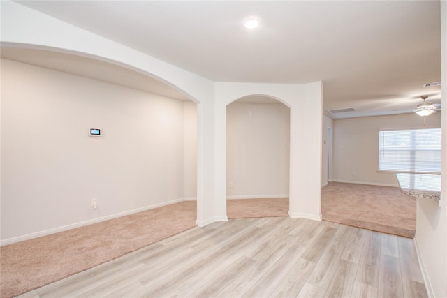 10699 Lost Maples Dr, Cleveland, TX 77328 - empty room featuring ceiling fan, light wood-style flooring, arched walkways, and baseboards