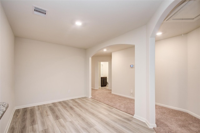 10699 Lost Maples Dr, Cleveland, TX 77328 - spare room with arched walkways, light wood-style floors, baseboards, recessed lighting, and attic access