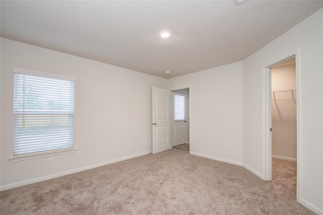 10699 Lost Maples Dr, Cleveland, TX 77328 - unfurnished bedroom with a walk in closet, light carpet, baseboards, and a closet