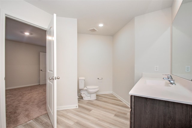 10699 Lost Maples Dr, Cleveland, TX 77328 - bathroom with toilet, vanity, wood finished floors, baseboards, and recessed lighting