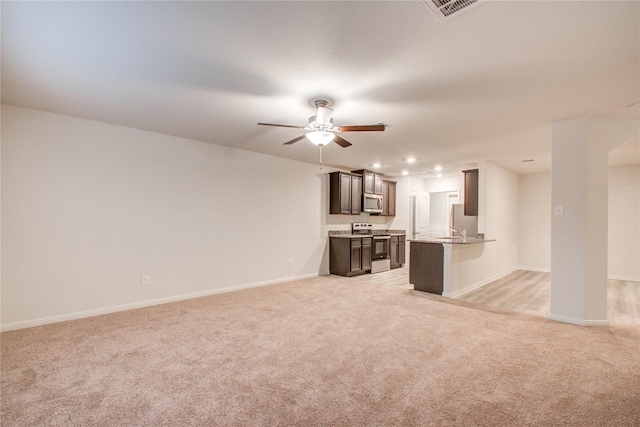 10699 Lost Maples Dr, Cleveland, TX 77328 - unfurnished living room featuring light carpet, ceiling fan, baseboards, recessed lighting, and a sink