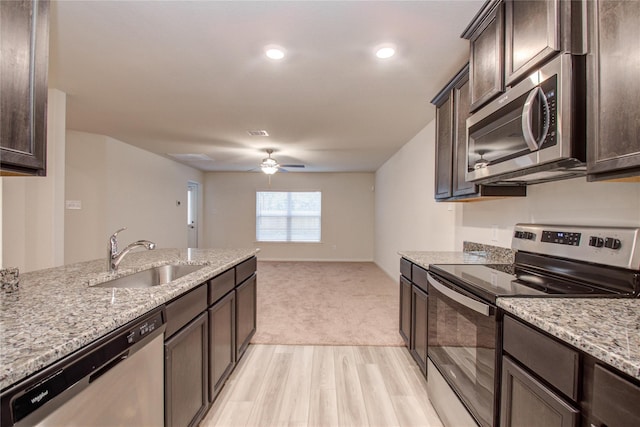10699 Lost Maples Dr, Cleveland, TX 77328 - kitchen featuring stainless steel appliances, a sink, dark brown cabinets, and a ceiling fan