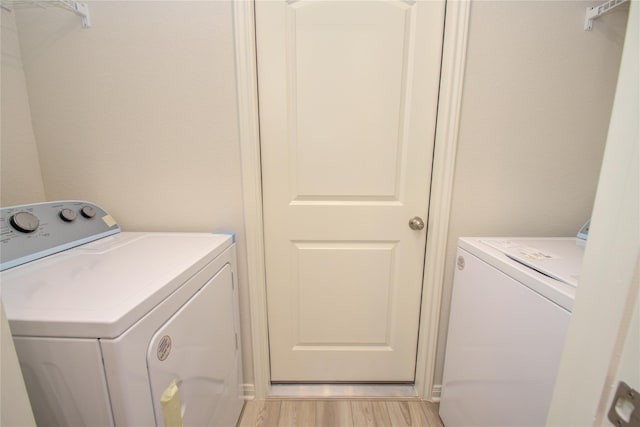 10699 Lost Maples Dr, Cleveland, TX 77328 - laundry room featuring washer and dryer and light wood-style flooring
