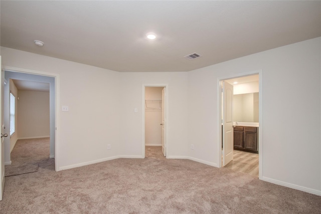 10699 Lost Maples Dr, Cleveland, TX 77328 - unfurnished bedroom featuring light carpet, a walk in closet, baseboards, ensuite bathroom, and a closet