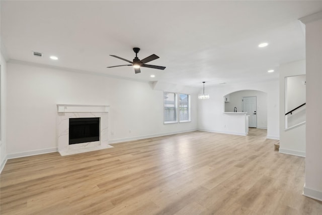 5847 Southington St, Houston, TX 77033 - unfurnished living room with a ceiling fan, recessed lighting, a high end fireplace, light wood-type flooring, and arched walkways