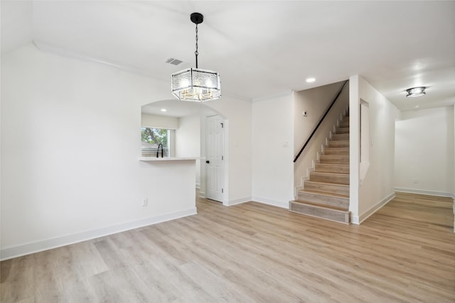5847 Southington St, Houston, TX 77033 - unfurnished living room with arched walkways, light wood-type flooring, stairway, a chandelier, and recessed lighting