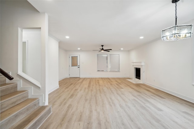 5847 Southington St, Houston, TX 77033 - unfurnished living room featuring recessed lighting, light wood finished floors, stairs, a ceiling fan, and a chandelier