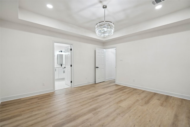 5847 Southington St, Houston, TX 77033 - spare room featuring a raised ceiling, a chandelier, light wood-style flooring, and recessed lighting