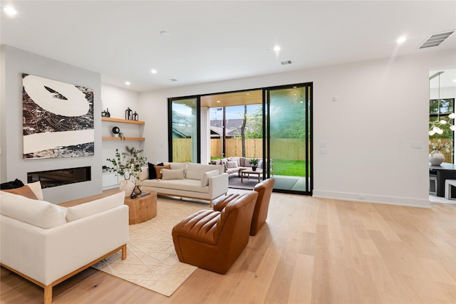 1741 Chippendale Rd, Houston, TX 77018 - living area featuring light wood-style flooring, healthy amount of natural light, recessed lighting, and a glass covered fireplace