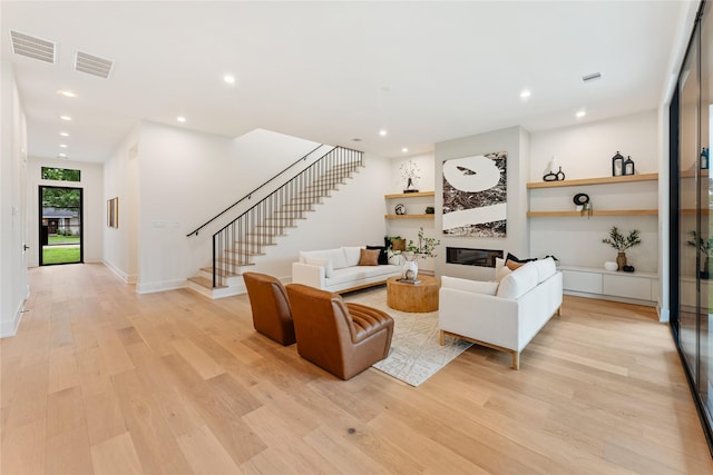 1741 Chippendale Rd, Houston, TX 77018 - living area with light wood-style flooring, stairway, a glass covered fireplace, and recessed lighting