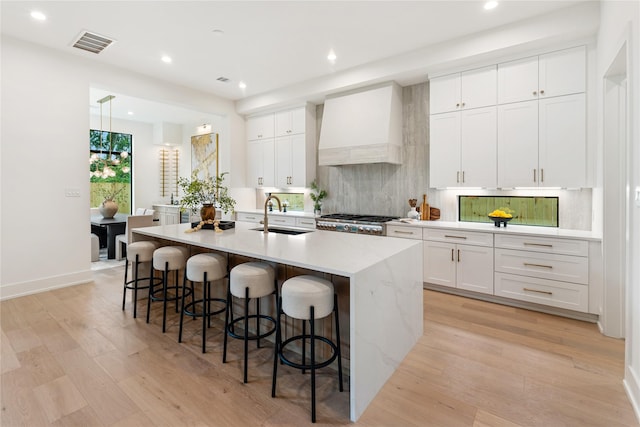 1741 Chippendale Rd, Houston, TX 77018 - kitchen featuring custom range hood, recessed lighting, backsplash, a center island with sink, and light wood finished floors