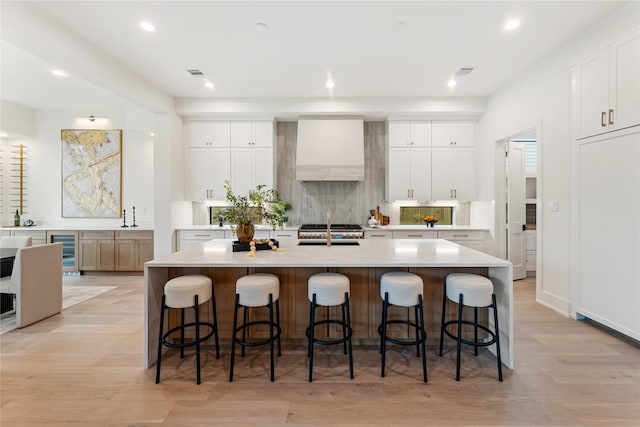 1741 Chippendale Rd, Houston, TX 77018 - kitchen with custom range hood, beverage cooler, a large island with sink, recessed lighting, and backsplash