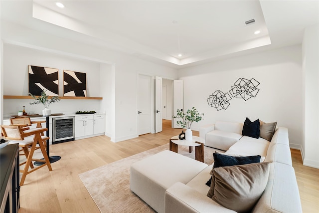 1741 Chippendale Rd, Houston, TX 77018 - living room with beverage cooler, a tray ceiling, recessed lighting, light wood-style floors, and a bar
