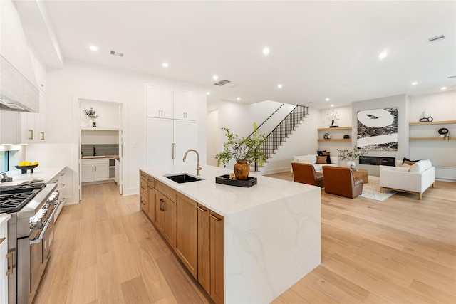 1741 Chippendale Rd, Houston, TX 77018 - kitchen featuring double oven range, light wood-style flooring, an island with sink, light stone counters, and recessed lighting
