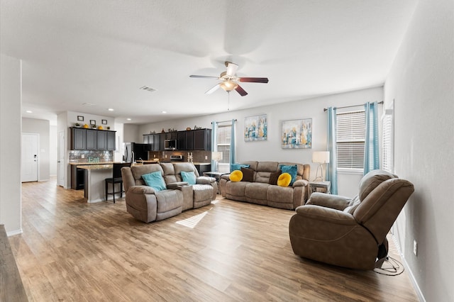 11375 Dawn Beach Ln, Conroe, TX 77304 - living room featuring wood finished floors, ceiling fan, plenty of natural light, and recessed lighting