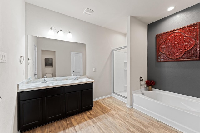 11375 Dawn Beach Ln, Conroe, TX 77304 - bathroom with wood finished floors, a shower stall, a garden tub, double vanity, and baseboards