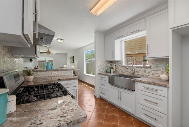 8702 Cold Lake Dr, Houston, TX 77088 - kitchen with a sink, stainless steel gas range oven, decorative backsplash, tile patterned flooring, and ceiling fan
