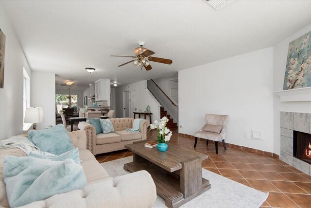 8702 Cold Lake Dr, Houston, TX 77088 - tiled living room with stairway, ceiling fan, a tile fireplace, and baseboards