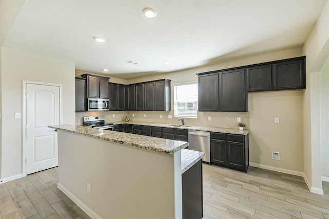 22303 Bauer Garden Dr, Hockley, TX 77447 - kitchen featuring appliances with stainless steel finishes, a sink, wood finish floors, and tasteful backsplash
