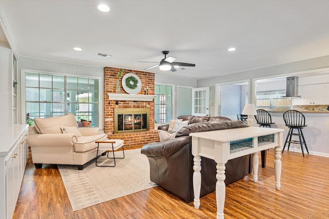 915 Timber Cove Dr, Seabrook, TX 77586 - living area featuring a ceiling fan, light wood-style flooring, plenty of natural light, a brick fireplace, and recessed lighting