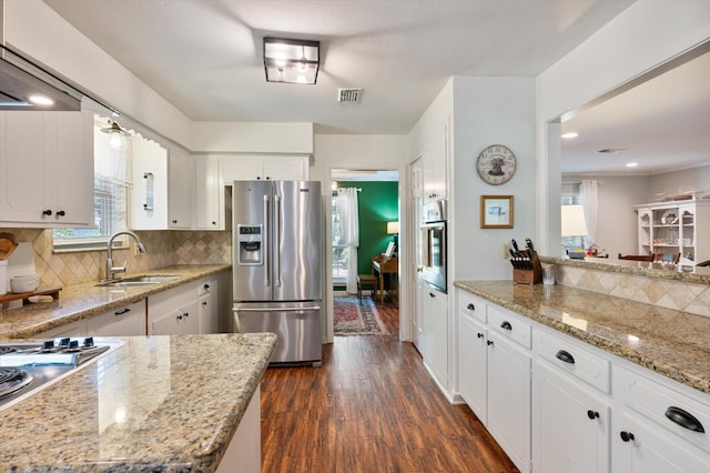 915 Timber Cove Dr, Seabrook, TX 77586 - kitchen featuring appliances with stainless steel finishes, a sink, dark wood-type flooring, decorative backsplash, and white cabinetry
