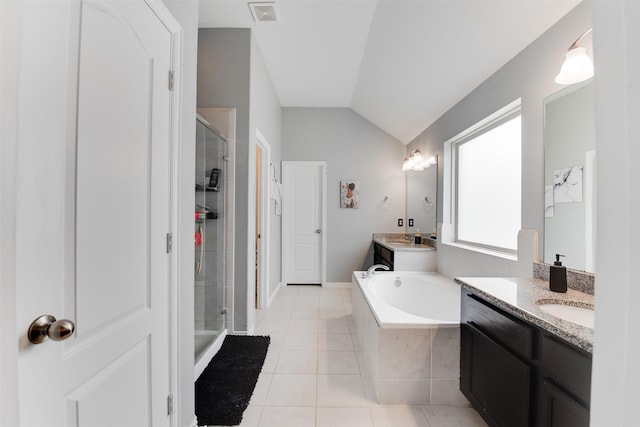 6734 Camden Valley Ct, Houston, TX 77084 - bathroom featuring a stall shower, two vanities, vaulted ceiling, tile patterned floors, and a garden tub