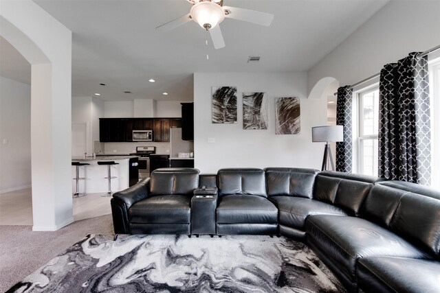 6734 Camden Valley Ct, Houston, TX 77084 - living room with arched walkways, a ceiling fan, light colored carpet, and baseboards