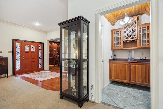1112 Jackson Blvd, Houston, TX 77006 - entryway with bar with sink, baseboards, lofted ceiling, light colored carpet, and ornamental molding