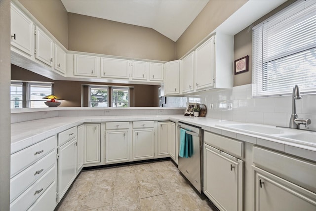 1112 Jackson Blvd, Houston, TX 77006 - kitchen with stainless steel dishwasher, vaulted ceiling, a sink, tile countertops, and white cabinetry