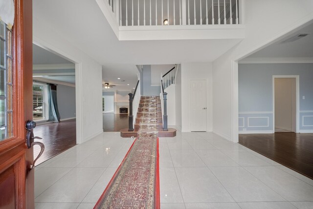 1818 Hillgreen Dr, Katy, TX 77494 - tiled foyer entrance with stairs, ornamental molding, baseboards, a wainscoted wall, and ceiling fan