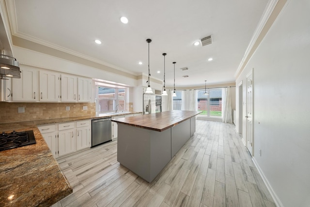 1818 Hillgreen Dr, Katy, TX 77494 - kitchen with stainless steel dishwasher, wood counters, plenty of natural light, ornamental molding, and a kitchen island