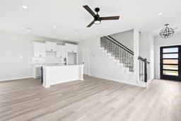 6418 Bolinas Ct, Rosharon, TX 77583 - unfurnished living room featuring light wood-style floors, stairs, ceiling fan, a chandelier, and baseboards