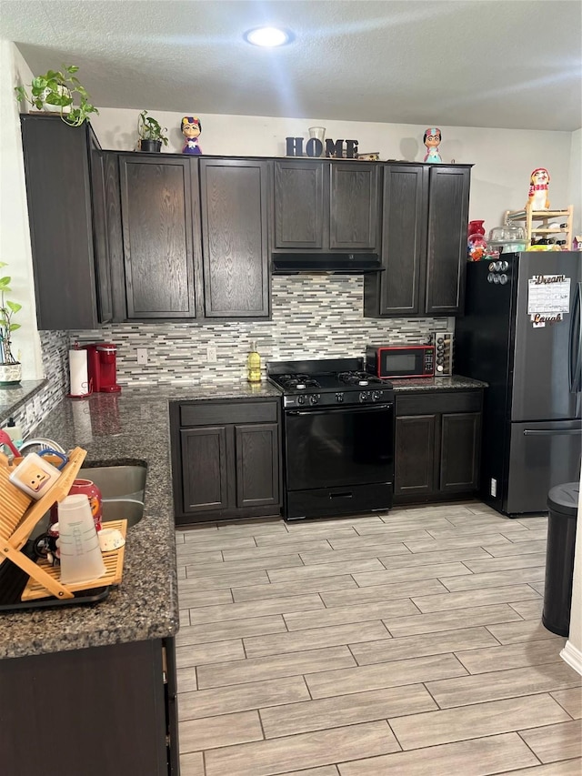 11111 Grape Hyacinth Ln, Houston, TX 77044 - kitchen with black gas stove, freestanding refrigerator, under cabinet range hood, and light wood finished floors