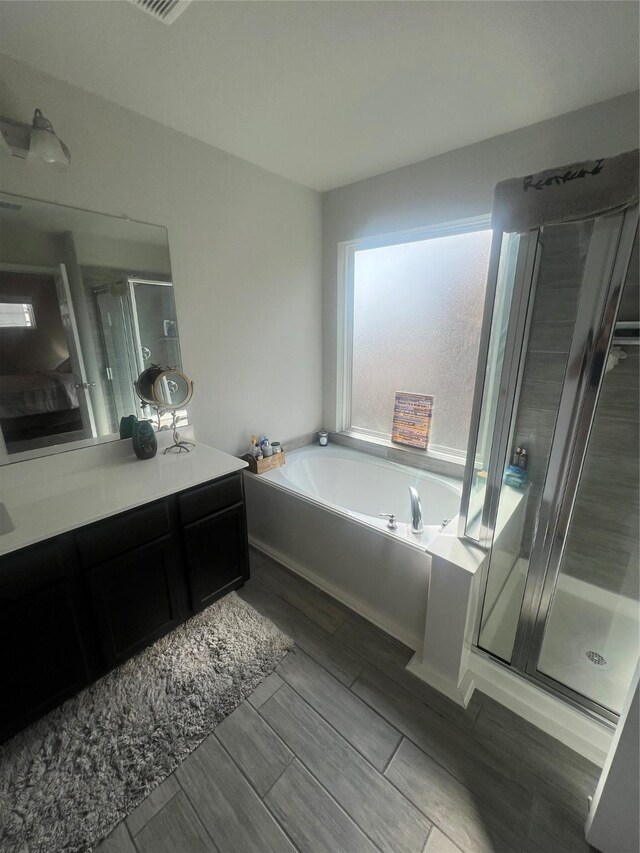 11111 Grape Hyacinth Ln, Houston, TX 77044 - full bath featuring vanity, a bath, a stall shower, and wood tiled floors
