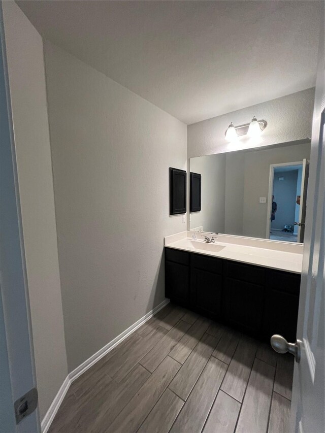 11111 Grape Hyacinth Ln, Houston, TX 77044 - bathroom with wood finish floors, vanity, and baseboards