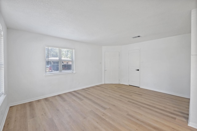 700 Lyle W Ave Unit B, Cleveland, TX 77327 - unfurnished room featuring light wood finished floors, a textured ceiling, and baseboards