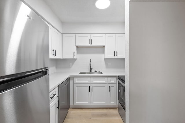 700 Lyle W Ave Unit B, Cleveland, TX 77327 - kitchen with stainless steel appliances, a sink, light countertops, white cabinetry, and tasteful backsplash