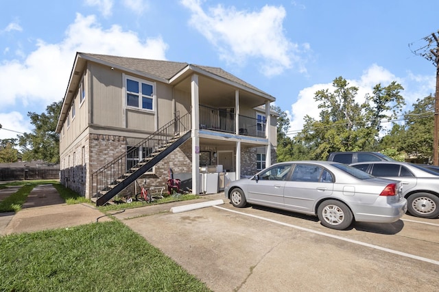 700 Lyle W Ave Unit B, Cleveland, TX 77327 - view of property with brick siding, uncovered parking, stairway, and a shingled roof